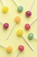 Sweet lollipops on yellow background photo