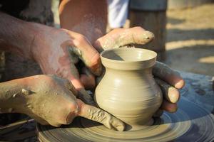 potter helps the child to make a vase from clay photo