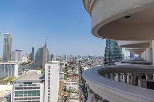 View of high-rise facades through a structure from balconies during the day photo