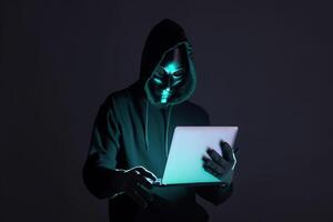 un hacker en un capucha utilizando un ordenador portátil computadora aislado en oscuro antecedentes con neón ligero. ai generado foto