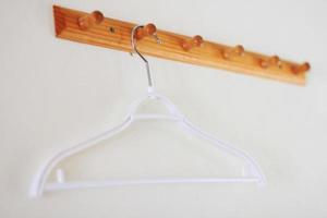 White coat hanger hanging on wooden vintage on concrete wall photo