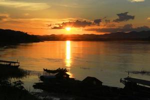 tradicion de largo cola barco y pescador en hermosa puesta de sol crepúsculo a khong río el tailandés-laos frontera chaingkhan distrito Tailandia foto