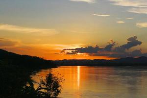 tradicion de largo cola barco y pescador en hermosa puesta de sol crepúsculo a khong río el tailandés-laos frontera chaingkhan distrito Tailandia foto