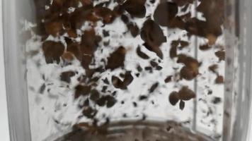 Slow motion footage of fresh coffee beans falling into glass container video