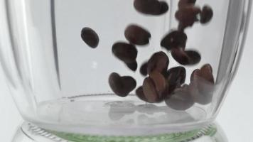 lento movimiento imágenes de Fresco café frijoles que cae dentro vaso envase video