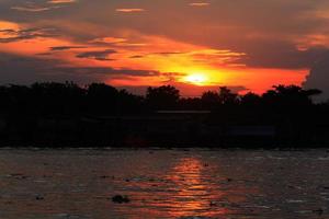 hermosa dramático de crepúsculo en puesta de sol en río y orilla en Tailandia foto