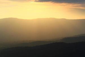 hermosa paisaje capas de montaña y brumoso en colina Valle en dorado crepúsculo de puesta de sol a Tailandia foto