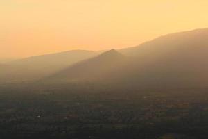 hermosa paisaje capas de montaña y brumoso en colina Valle en dorado crepúsculo de puesta de sol a Tailandia foto