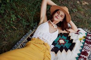 Woman laying on boho rug outdoors photo