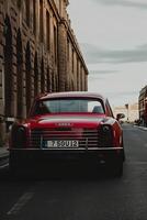 A red vehicle driven on road photo