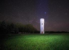 landscape with water tower against night sky photo