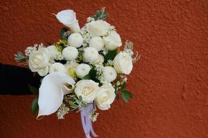 flower bucket in hand against red wall background photo