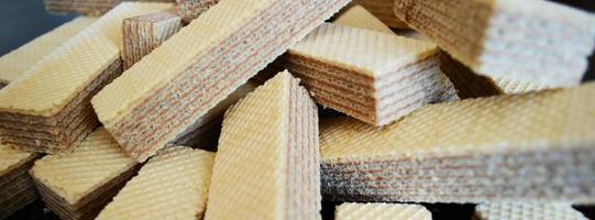 a handful of waffles, a bunch of sweets, striped waffles, waffles and crumbs on the table photo