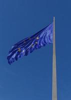 European Union flag on flagpole against blue sky photo