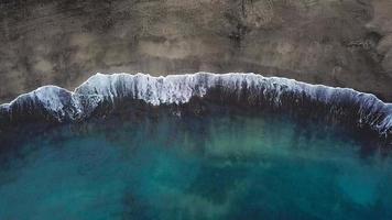 Haut vue de une déserté plage. côte de le île de tenerife. aérien drone métrage de mer vagues atteindre rive video