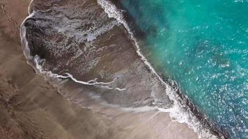parte superior ver de un abandonado playa. costa de el isla de tenerife aéreo zumbido imágenes de mar olas alcanzando apuntalar video