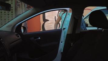 mulher colocar uma Jaqueta em a carro assento e senta baixa em a motorista assento, pretendendo para começar a motor video