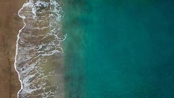 Haut vue de une déserté plage. côte de le île de tenerife. aérien drone métrage de mer vagues atteindre rive video