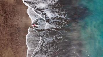 superiore Visualizza di un' abbandonato spiaggia. costa di il isola di tenerife. aereo fuco metraggio di mare onde raggiungendo riva video