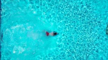 View from the top as a man jumping and dives into the pool and swims under the water video