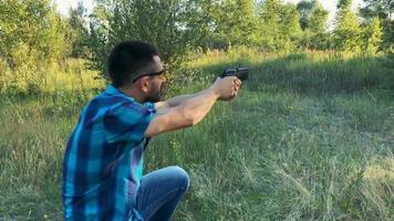 joven hombre con un pistola es puntería a disparar un cerca arriba video