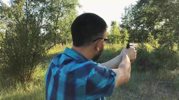 jung Mann mit ein Gewehr ist Zielen zu schießen ein schließen oben video