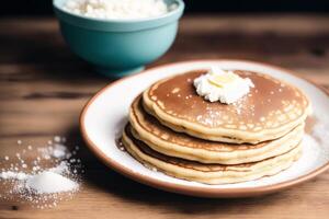 Stack of pancakes with maple syrup and sugar powder on a white plate. strawberries and whipped cream, photo