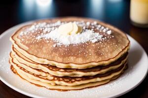 Stack of pancakes with maple syrup and sugar powder on a white plate. strawberries and whipped cream, photo