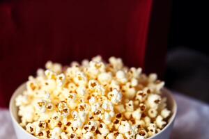 Popcorn in a cup on a wooden background. photo