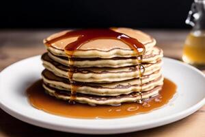 Stack of pancakes with maple syrup and sugar powder on a white plate. strawberries and whipped cream, photo