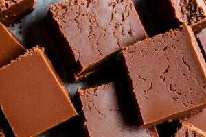 Fudge on a white plate on a wooden table. Homemade fudge cookies, candies with nuts. photo