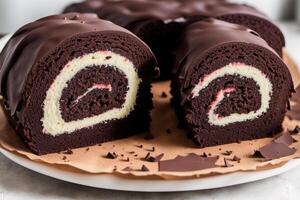 A swiss roll on a white plate on a wooden table. Homemade chocolate roll. Red velvet cake. photo