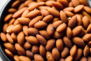 Almond nuts in white bowl on wooden table. Healthy snack. photo