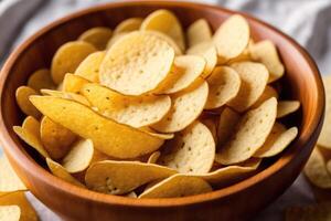 Potato chips in a bowl on a wooden background. photo