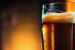 glass of beer with foam on a dark background, close-up. photo