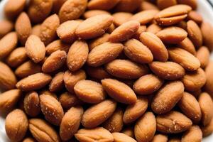 Almond nuts in white bowl on wooden table. Healthy snack. photo