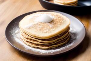 Stack of pancakes with maple syrup and sugar powder on a white plate. strawberries and whipped cream, photo