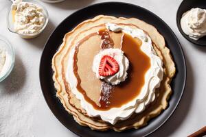 Stack of pancakes with maple syrup and sugar powder on a white plate. strawberries and whipped cream, photo