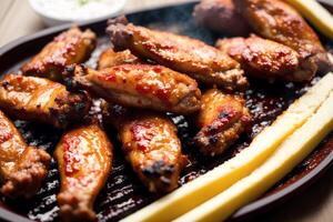 Grilled chicken wings with sweet and sour sauce on a white plate.Grilled sausages , Delicious barbecue ribs. photo