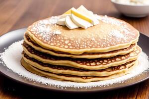 Stack of pancakes with maple syrup and sugar powder on a white plate. strawberries and whipped cream, photo