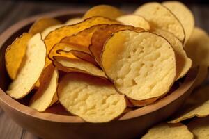 Potato chips in a bowl on a wooden background. photo