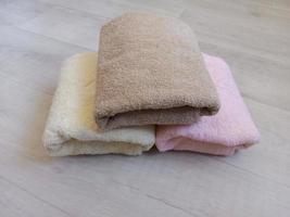 folded towels in pastel color on wooden background photo