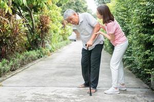 Asian senior man walking in the backyard and painful inflammation and stiffness of the joints Arthritis and the daughter came to help support. Concept of old elderly insurance and health care photo