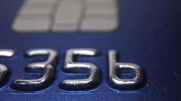 Panning shot of credit card numbers on a blue bank payment card video