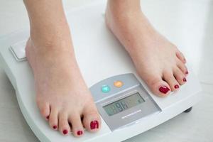 Close-up of a woman's feet while measuring her weight and body fat percentage photo