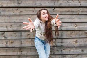 niña feliz sonriendo. retrato de belleza joven mujer morena riendo positiva feliz sobre fondo de pared de madera foto