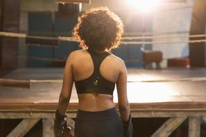 Women self defense. African woman fighter preparing for competition fight going to boxing ring. Strong girl ready for fight active exercise sparring workout training. Training day in boxing gym. photo