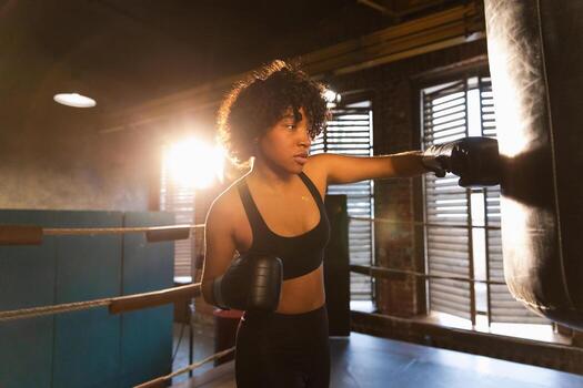 mujer yo defensa niña fuerza. africano americano mujer combatiente formación puñetazos en boxeo anillo. sano fuerte niña puñetazos boxeo bolsa. formación día en boxeo gimnasia. fuerza ajuste cuerpo rutina de ejercicio capacitación. foto