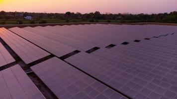 Generate clean energy with solar modules in a large park field in Asia from aerial view by drone during sunset. photo