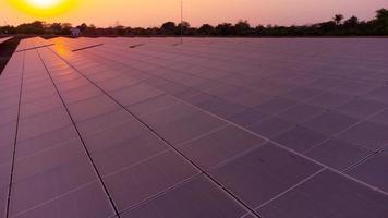 generar limpiar energía con solar módulos en un grande parque campo en Asia desde aéreo ver por zumbido durante puesta de sol. foto